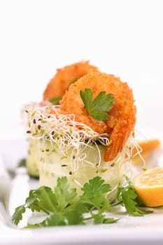 Cucumber appetizer with fried breaded shrimp on a bed of microgreens