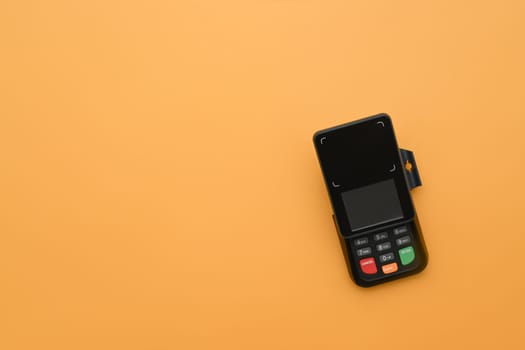 Modern payment terminal on yellow background. Modern payment systems concept.