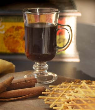 Close-up photo of a cup of coffee with crunchy biscuits. Natural light