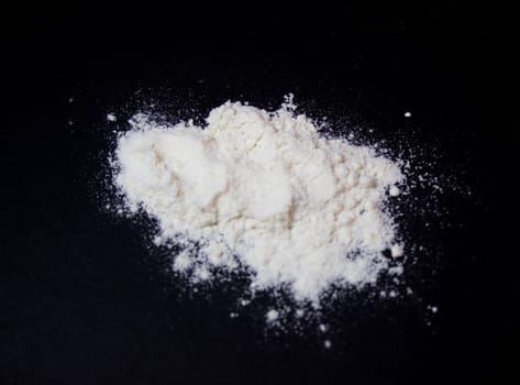 Top view picture of wheat flour, isolated on dark background. Ingredient for gourmet food.