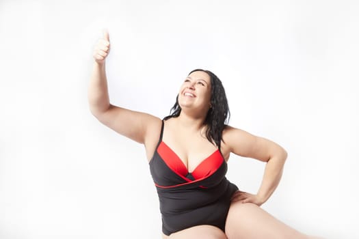 Happy attractive thick woman in swimsuit posing on white background. Body positive, photoshoot, selfie. Funny plus size model, Winner in Weight loss