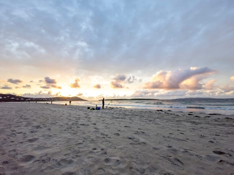 20 man are competing in a fishing competition on the beach