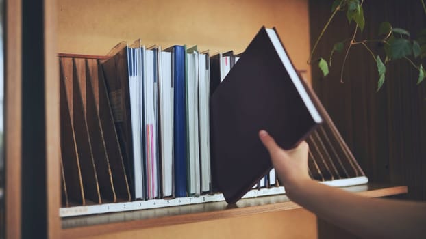 The teacher takes a school teacher's magazine from the shelf