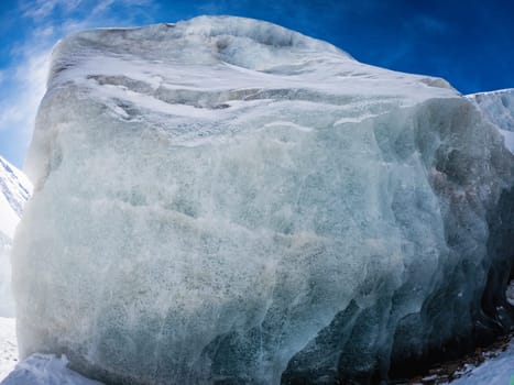 A huge natural piece of ice against a blue sky, can be used as a background with copy space.