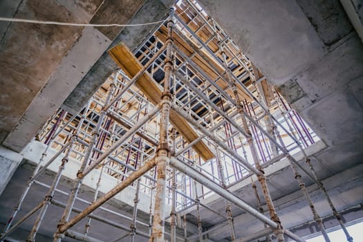 Scaffolding on a construction site is assembled in a staircase for the movement of workers between floors.