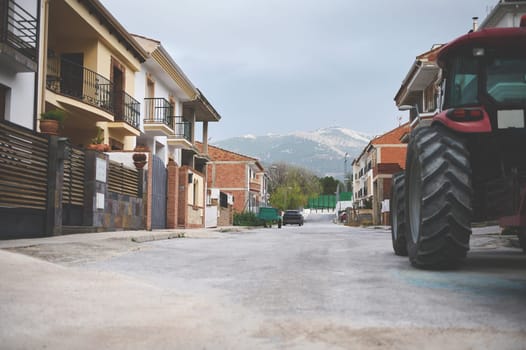 Luxury cottages and villas in the city of Quesada of the region of Jaen in Spain. A partial view of tractor parked on the road. The province of Jaen. Olive paradise. Countryside and rural lifestyle