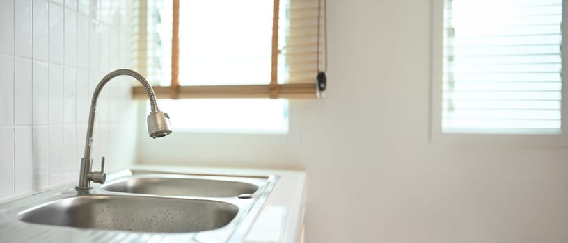 Stainless steel kitchen sink with faucet in the minimal kitchen interior.