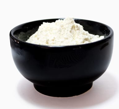 Side picture of a bowl containing flour. Ingredient for preparing cakes and pastries. Close-up photo