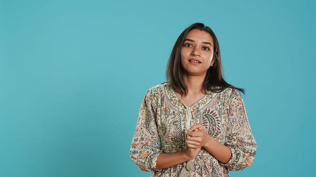 Portrait of jealous indian woman mockingly clapping hands, isolated over studio background. Annoyed person rolling eyes and applauding in jest, doing fake cheering, camera A