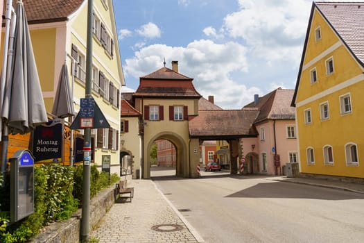 Feuchtwangen, Germany - June 6, 2023: A picturesque view of a historic stone archway and surrounding buildings in a charming Bavarian town.