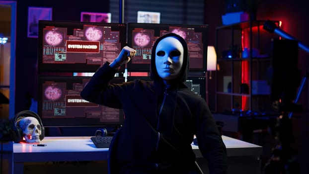 Dissident social justice crusader doing online activism, wearing anonymous masks and filming video in underground bunker, blackmailing government after stealing secret military documents, camera B