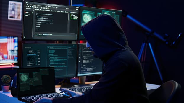 Hacker arriving in hidden underground shelter, prepared to launch DDoS attack on websites. Cybercriminal in apartment starting work on script that can crash businesses servers, camera B
