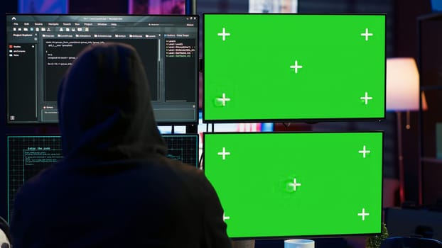 Dangerous man hacking using isolated screen PC, stealing credit card information and breaching banking systems. Hacker running code in apartment on chroma key computer display, close up, camera A