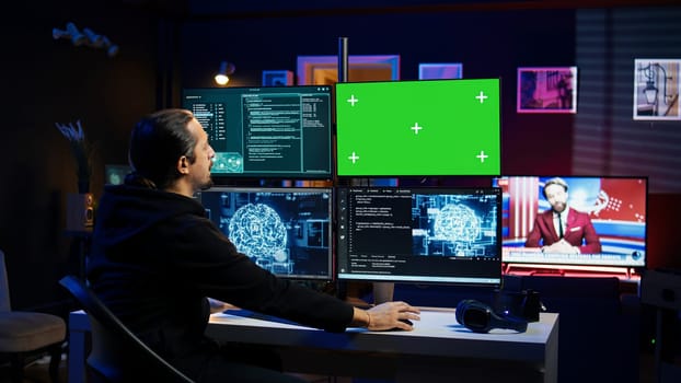 Hacker using green screen monitor and artificial intelligence to write spyware software gathering data from users. Scammer in apartment using AI and mockup PC display to do fraud using AI, camera B