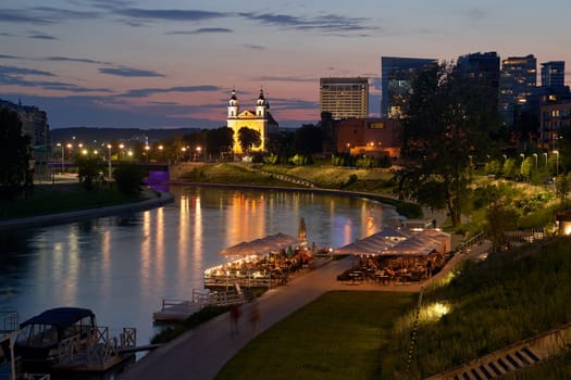 Vilnius night panoramic cityscape with Neris river, church and skyscrapers of New Center. Lithuania, Baltic states.