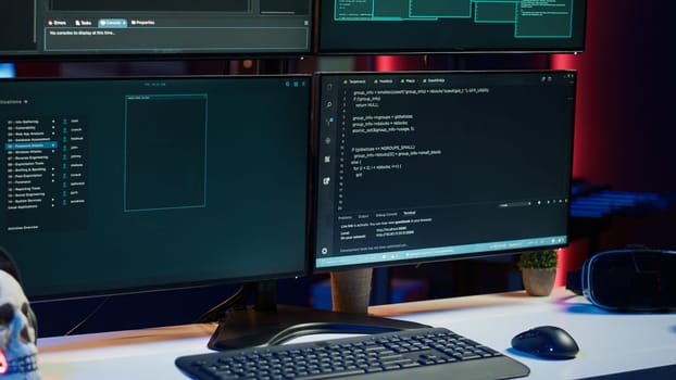 Close up shot of dangerous hacking code running on high tech computer system monitors. Programming scripts shown on PC displays in empty criminal hideout used by hackers to commit illegal activities