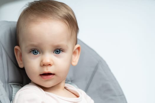 Close-up of an infant baby gazing at the camera with wide-eyed wonder