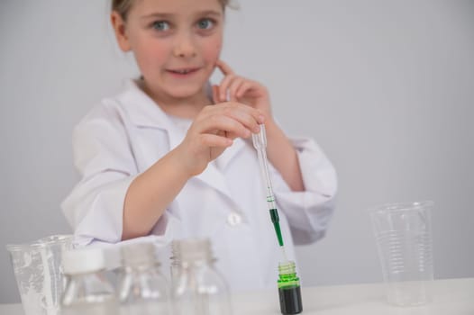 Caucasian girl doing chemical experiments on a white background