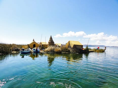 Thatch-roofed reed houses on the floating uros islands, under a clear blue sky in puno