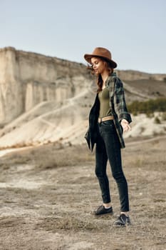 serene woman in plaid shirt and hat standing confidently in vast open field