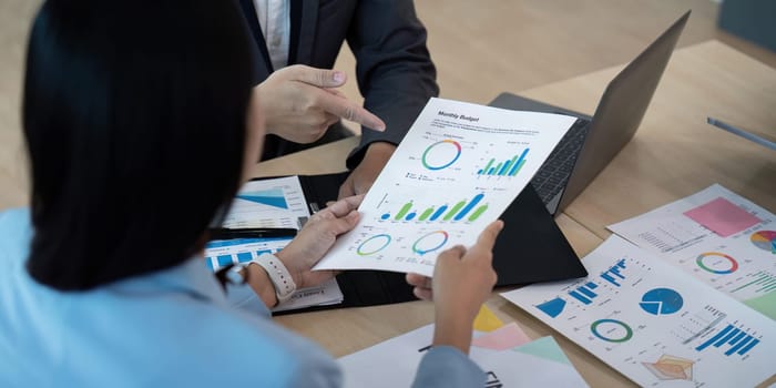 Business team analyzing financial reports with charts and graphs in a modern office setting, emphasizing strategy and data-driven decision-making