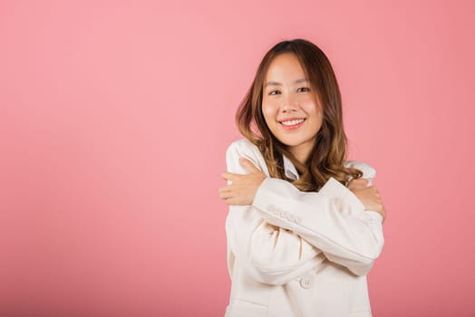 Happy beautiful young smiling Asian businesswoman hugging herself remember moment studio short isolated on pink background, Self care and self esteem concept, Lifestyle female love yourself carefree