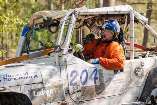 REPUBLIC OF KARELIA, RUSSIA - CIRCA JUNE, 2022: Off-road tournament Ladoga Trophy 2022 in Karelia. Emotional portrait of a racer driver driving a 4x4 jeep SUV during a race