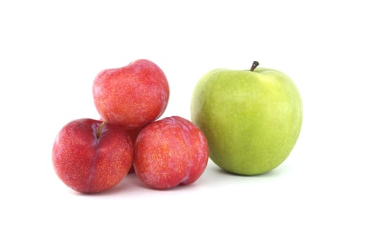 Assortment of fresh fruits set against a white backdrop, including vivid green apples and crimson plums