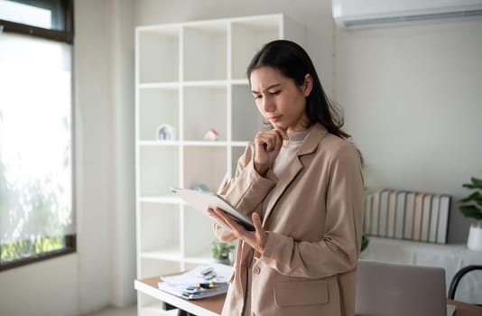 Unhappy Asian businesswoman showing stress over unsuccessful business in Home Office.