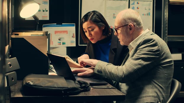 Law officers reading confidential folders in archive room at private company, gathering information to conduct investigation. Detectives create timelines based on archived records. Camera A.