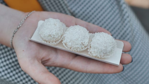 Three coconut candies on the girl's arm