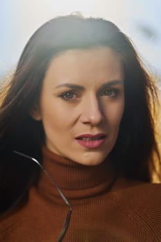 Beautiful young brunette woman in golf poses on meadow on sunny day