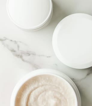 Scrub and exfoliating cream products on a marble, flatlay - skincare and body care, luxury spa and clean cosmetic concept. Health and beauty of your skin