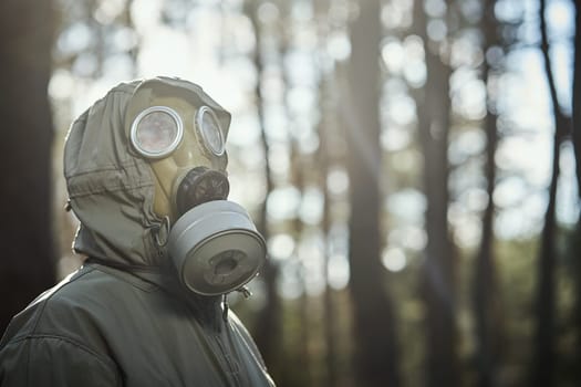 man in a gas mask protects himself from coronavirus in the woods