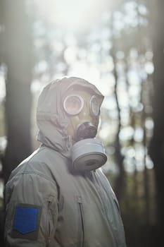 man in a gas mask protects himself from coronavirus in the woods