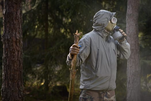 man in a gas mask protects himself from coronavirus in the woods