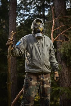 man in a gas mask protects himself from coronavirus in the woods