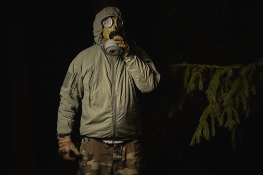 man in a gas mask protects himself from coronavirus at night