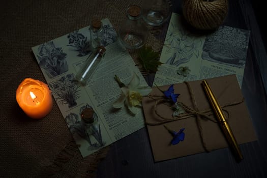 Mystical still life in vintage style with empty flasks, burning candles, letters and newspaper clippings. High quality photo