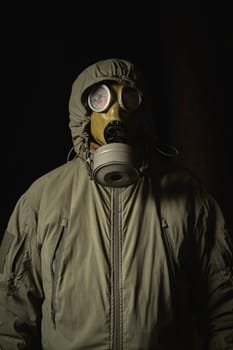 man in a gas mask protects himself from coronavirus at night