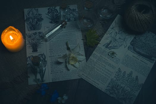 Mystical still life in vintage style with empty flasks, burning candles, letters and newspaper clippings. High quality photo