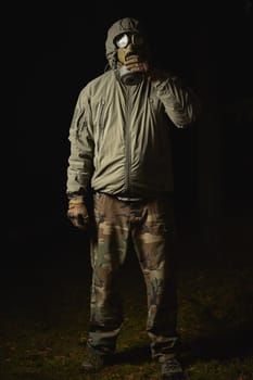 man in a gas mask protects himself from coronavirus at night