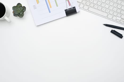 Office desk with financial reports, keyboard and cup of coffee. Top view with copy space.