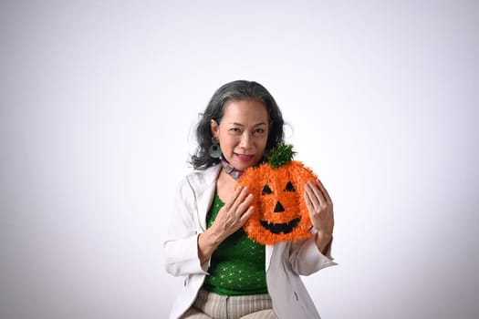 Senior woman holding halloween pumpkin baskets isolated white background.