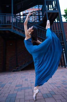 Beautiful Asian ballerina dancing outdoors. Urban landscape