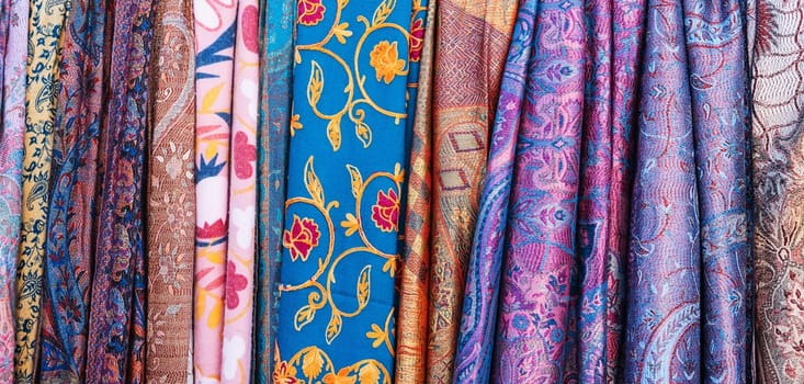 Traditional silk Uzbek scarves with colorful pattern at the oriental bazaar in Tashkent in Uzbekistan close-up