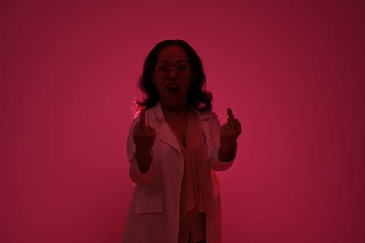 Silhouettes of middle age woman showing middle finger gesture over red background.