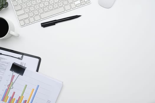 Top view financial reports and cup of coffee on white office desk.