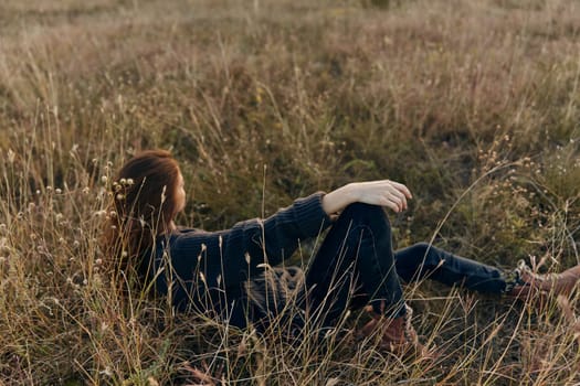 Serene woman sitting crosslegged in lush grassy field on a sunny day