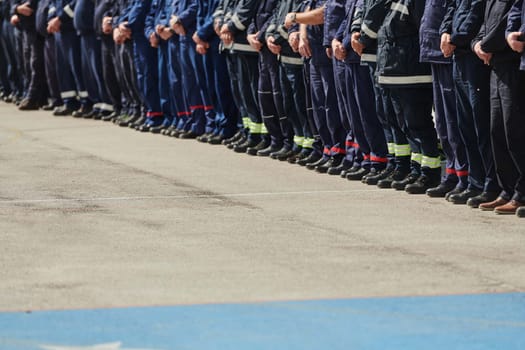 A group of firefighters lined up, saluting the flag, applauding in solidarity, and gearing up for intensive training sessions, showcasing their unwavering commitment to service and teamwork